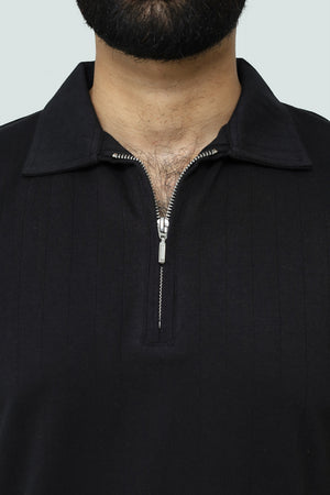 Close-up of a black V neck zip-up polo with a neutral background