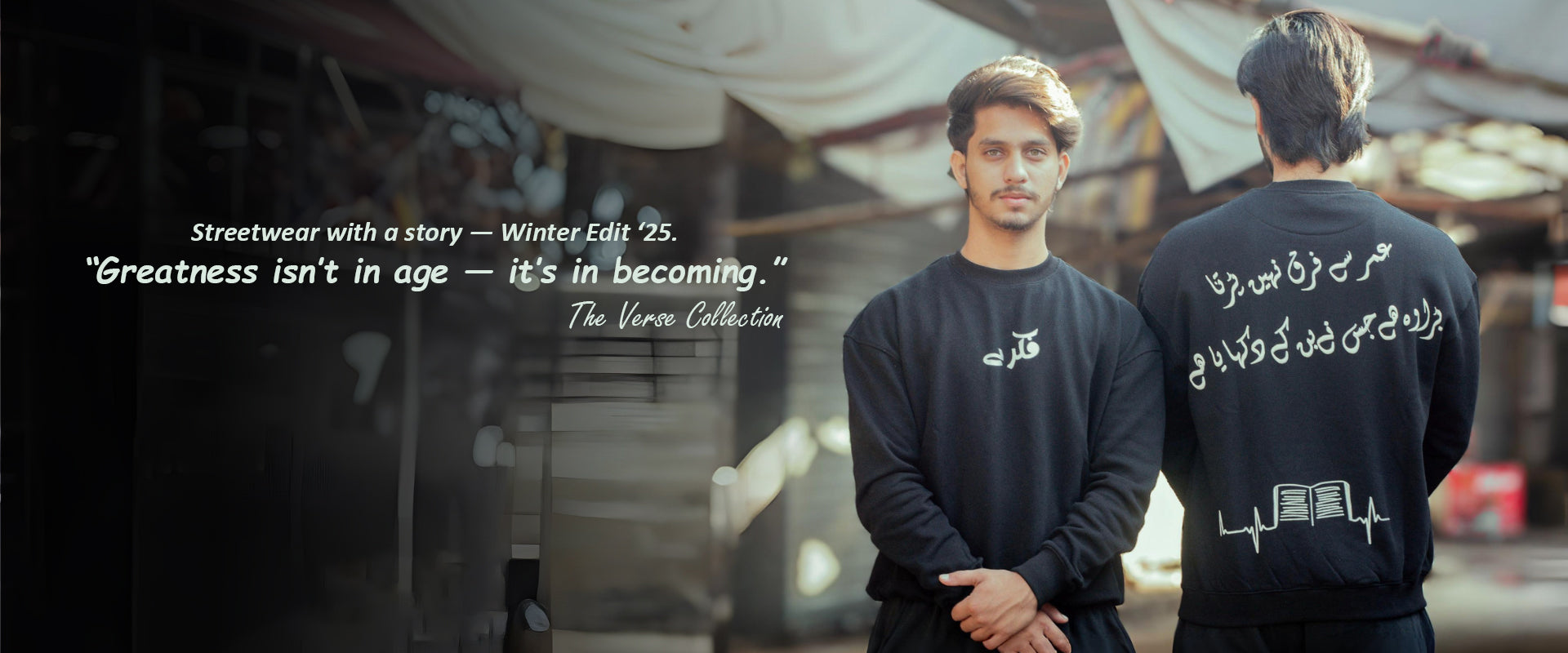 Two men wearing black sweatshirts with text, standing outdoors with a quote about greatness.
